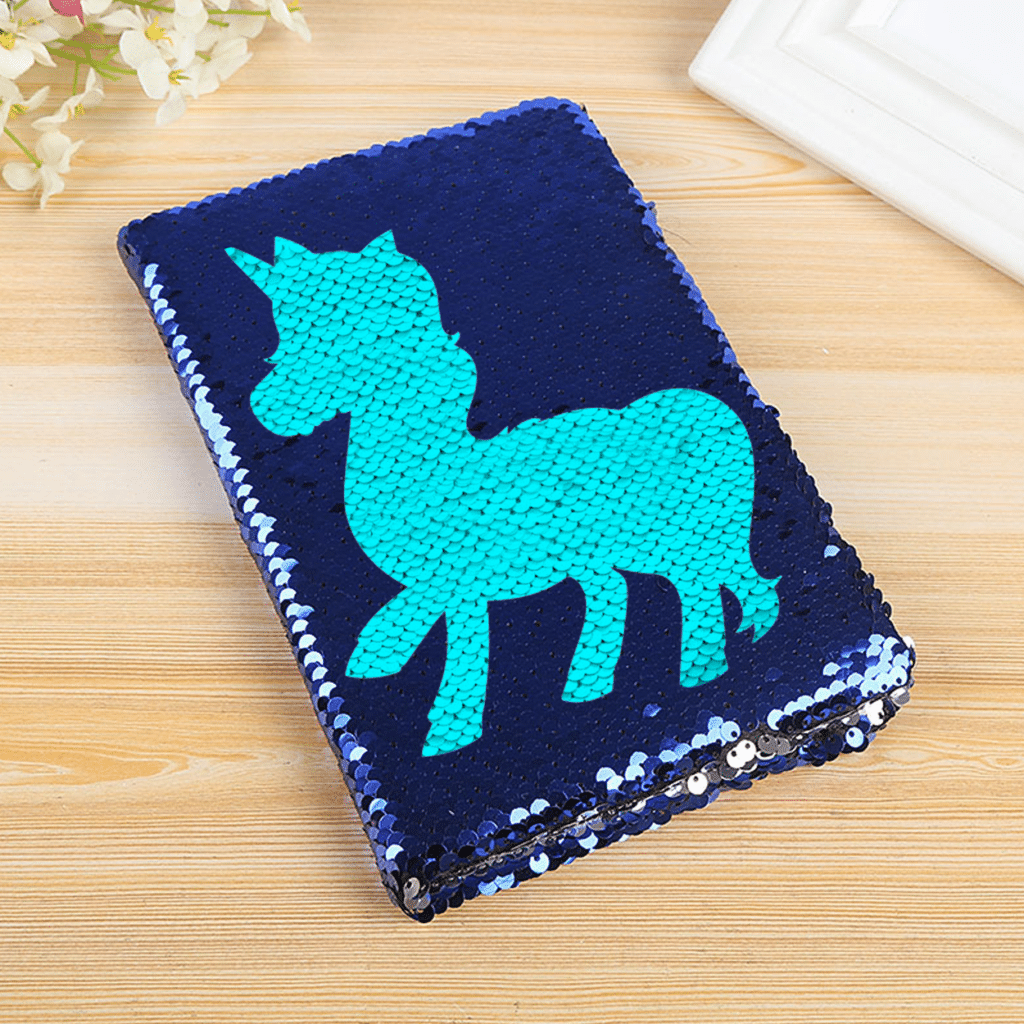 Whimsical navy blue sequin notebook with a vibrant turquoise unicorn design for magical journaling.